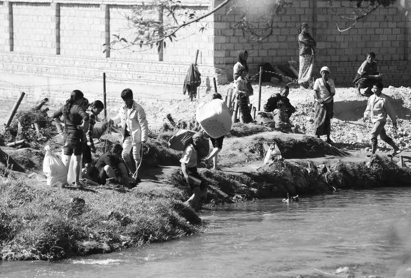 22日,缅甸边民过河进入中国畹町。